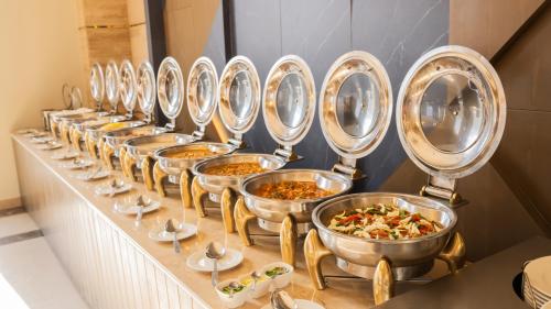 a row of silver bowls of food on a table at Ramada Resort by Wyndham Gilgit in Gilgit
