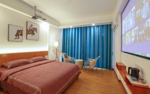 a bedroom with a bed and a flat screen tv at Zhangjiajie Warm Wind Inn in Zhangjiajie