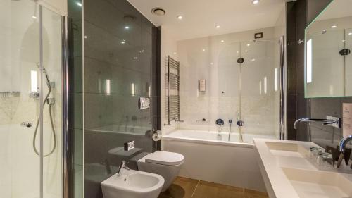 a bathroom with a toilet and a sink and a shower at Isola di Albarella Golf Hotel in Isola Albarella