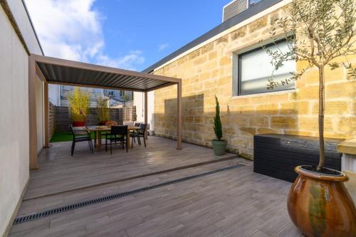 une terrasse avec une table et des chaises dans l'établissement OIQIA • Burdigala, à Bordeaux