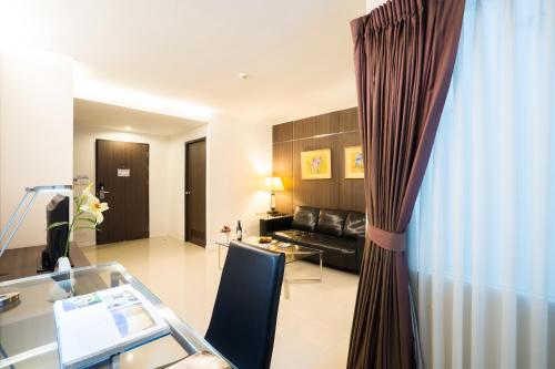 a living room with a glass table and a couch at Beyond Suite in Bangkok