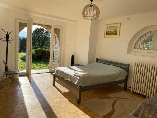ein Schlafzimmer mit einem Bett und einer offenen Tür in der Unterkunft Grande maison et piscine privée in Saint-Ambroix