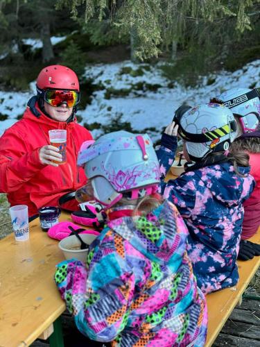 a group of children sitting at a picnic table in the snow at Gasthof Frasswirt in Frass