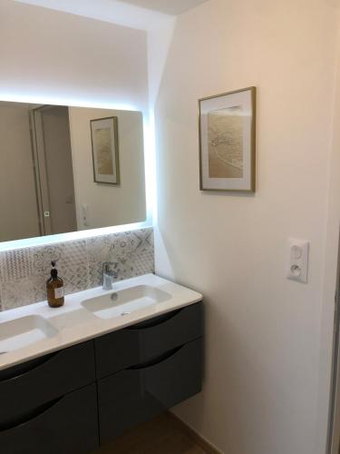 une salle de bain avec un lavabo et un miroir dans l'établissement Appartement cosy à 100m de la plage, à La Bernerie-en-Retz