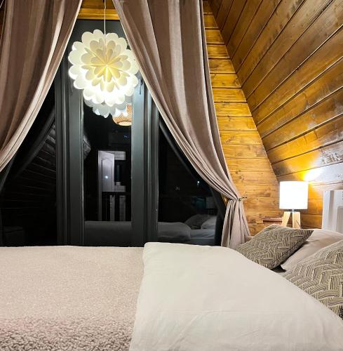 a bedroom with a bed and a large window at Roman A Frame Vișeu de Sus in Vişeu de Sus