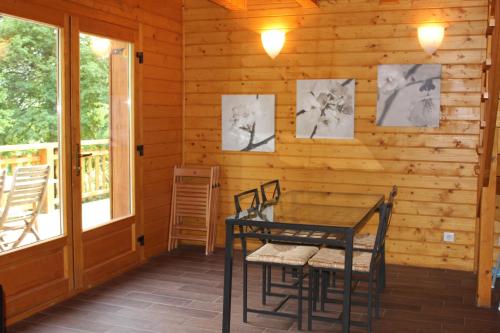 ein Esszimmer mit einem Tisch und Stühlen in einer Hütte in der Unterkunft Le Chalet du Berger in Briançonnet