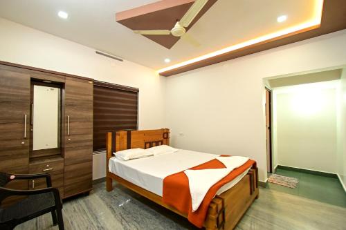 a bedroom with a bed and a sliding glass door at San WAYANAD HOMESTAY AND SERVICE VILLA in Sultan Bathery