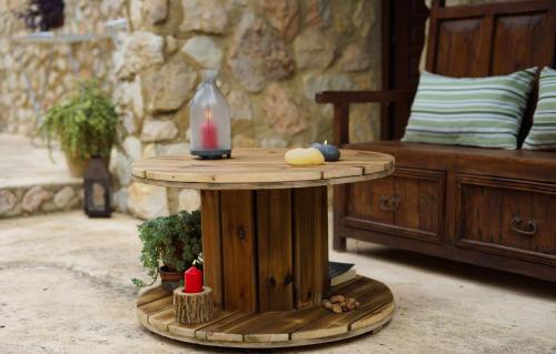 a table with a candle on top of it next to a bed at Torre de Arriba Casa Rural in Benimantell