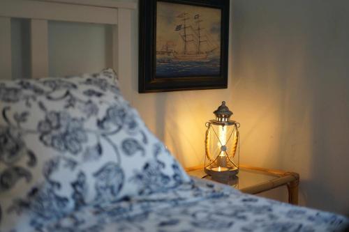 a bed with a blue and white pillow and a lamp at Torre de Arriba Casa Rural in Benimantell