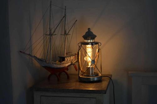 a glass lantern with a boat in it on a table at Torre de Arriba Casa Rural in Benimantell