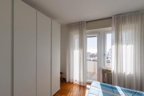 ein Schlafzimmer mit einem Bett und einem großen Fenster in der Unterkunft 282 - Casa Boscobello, Terrazzo vista Mare e Parcheggio Privato a 15 minuti a piedi dal Teatro Ariston in Sanremo