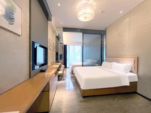 a hotel room with a bed and a television at Vaperse Hotel Guangzhou Zhujiang New Town - Free Shuttle Bus & Registration Counter During Canton Fair in Guangzhou