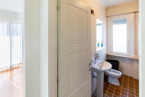 ein Badezimmer mit einer weißen Tür und einem Waschbecken in der Unterkunft 282 - Casa Boscobello, Terrazzo vista Mare e Parcheggio Privato a 15 minuti a piedi dal Teatro Ariston in Sanremo