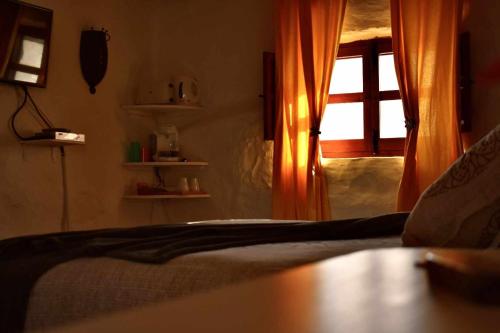 a bedroom with a bed with an open window at Torre de Arriba Casa Rural in Benimantell