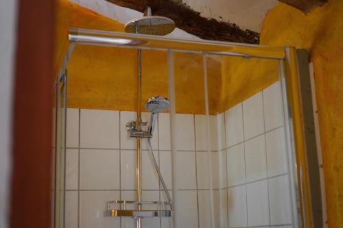 a shower in a bathroom with white tiles at Torre de Arriba Casa Rural in Benimantell
