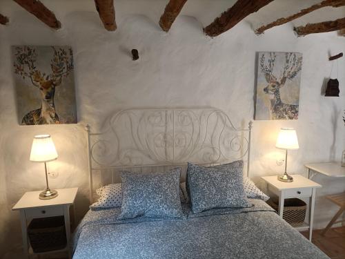 a bedroom with a bed with two tables and two lamps at Torre de Arriba Casa Rural in Benimantell