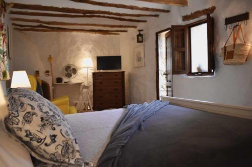 a bedroom with a bed and a window and a television at Torre de Arriba Casa Rural in Benimantell