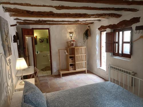 a bedroom with a bed and a bathroom at Torre de Arriba Casa Rural in Benimantell