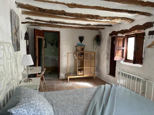 a bedroom with a bed and a table and window at Torre de Arriba Casa Rural in Benimantell