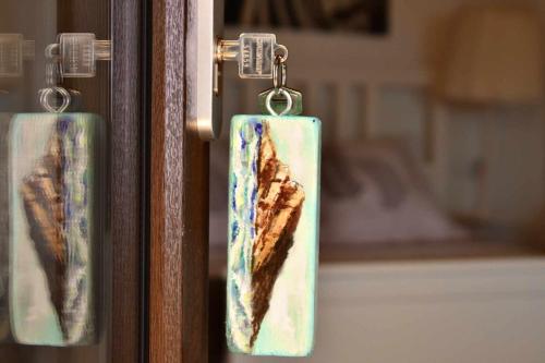 a pair of tags hanging from a door at Torre de Arriba Casa Rural in Benimantell