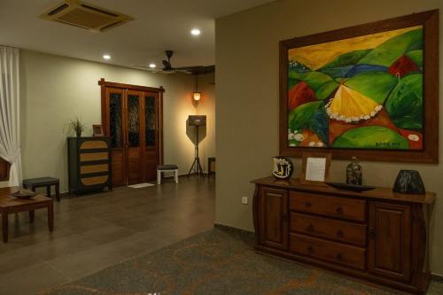 a living room with a large painting on the wall at Ori Bali House Muar in Muar