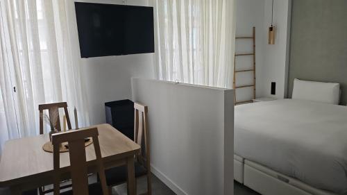 Un dormitorio con una cama, una mesa y una silla. en Suite Foro Romano 2 huespedes, en Córdoba