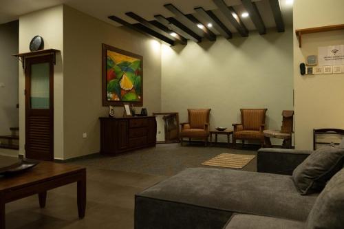 a living room with a couch and a table and chairs at Ori Bali House Muar in Muar