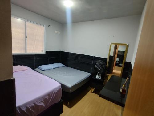 1 Schlafzimmer mit 2 Betten, einem Fenster und einem Spiegel in der Unterkunft Parque Caminho das Baraúnas in Caruaru