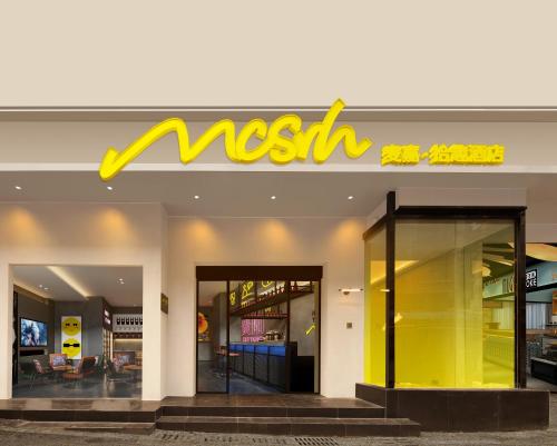 a nissil store with a yellow sign on the facade at Mcsrh Hotel-Guiyang Penshuichi in Guiyang
