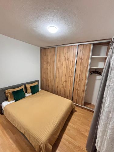 a bedroom with a bed with a wooden wall at R-RESIDENCY ll in Banja Luka