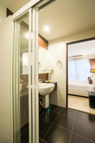 a bathroom with a sink and a mirror at Beyond Suite in Bangkok