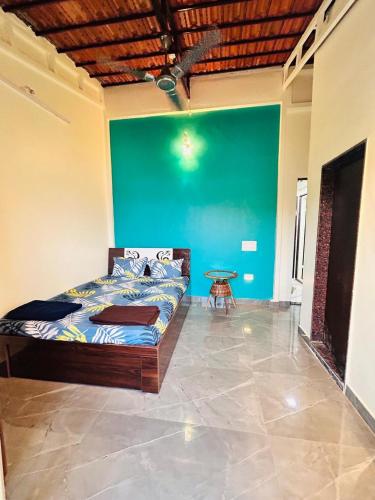 a bedroom with a bed and a green wall at Shree Samartha Guest House in Jejūri