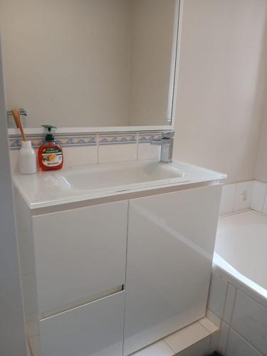 a white kitchen with white cabinets and a shelf at Ocean breeze villa in Preston Beach
