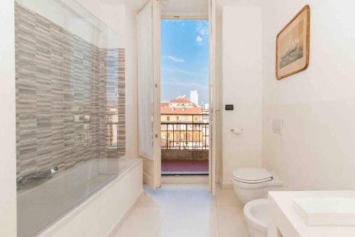 Un baño con bañera, inodoro y ventana. en Luxury City Retreat with Breathtaking View, en Turín