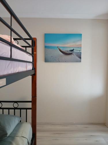 a bedroom with a bunk bed and a picture of a boat at Ocean breeze villa in Preston Beach