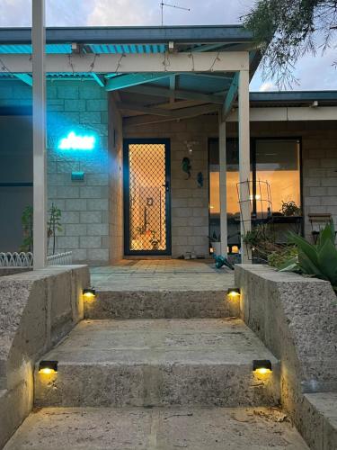 a house with a porch with lights on the stairs at Ocean breeze villa in Preston Beach