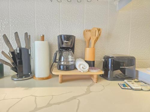 a kitchen counter with a coffee maker and utensils at Beautiful Apartment 10 min from Bayahibe beach Las Terrazas in Bayahibe