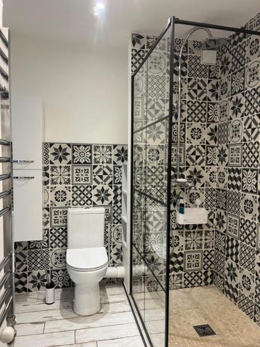 La salle de bains est pourvue de toilettes et de carrelage noir et blanc. dans l'établissement Spacieux studio plein sud et très calme, à Cagnes-sur-Mer