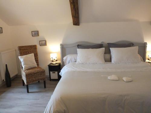 ein Schlafzimmer mit einem großen Bett und einem Stuhl in der Unterkunft Au Jardin de Pagès Chambres d'Hôtes et Gîtes in Lias-dʼArmagnac