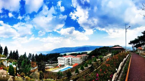 a view of a building and a garden with flowers at La Nicholas Lake View by Summit Hotels in Mawlyngkhung