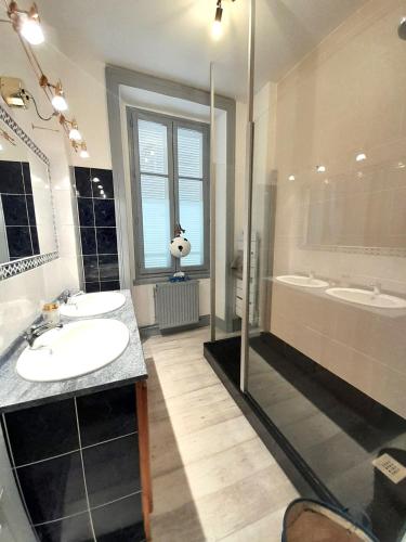 La salle de bains est pourvue de 2 lavabos, d'une douche et d'une baignoire. dans l'établissement Belle Maison centrale 8 pers- patio- wifi, à Châteauroux