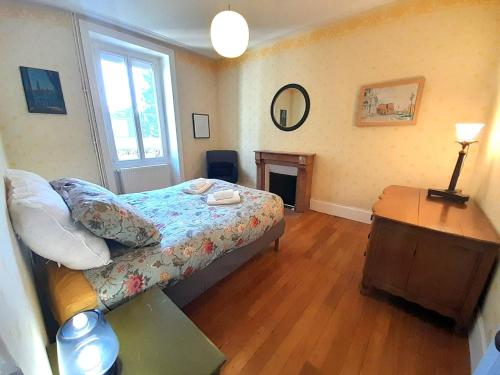 a bedroom with a bed and a table and a mirror at Belle Maison centrale 8 pers- patio- wifi in Châteauroux