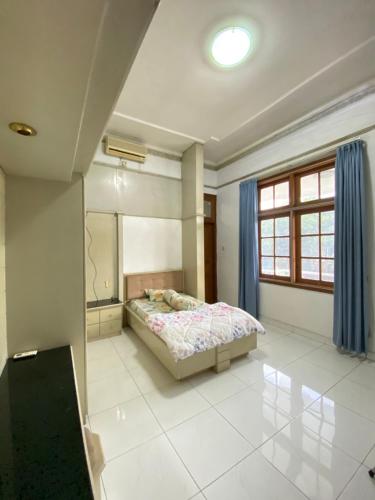 a bedroom with a bed and a large window at Bimo Inn Malioboro in Jetis