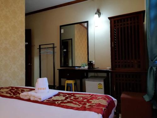 a bedroom with a bed with a hat on it at ShuYa Hotel 舒雅酒店 in Luang Prabang