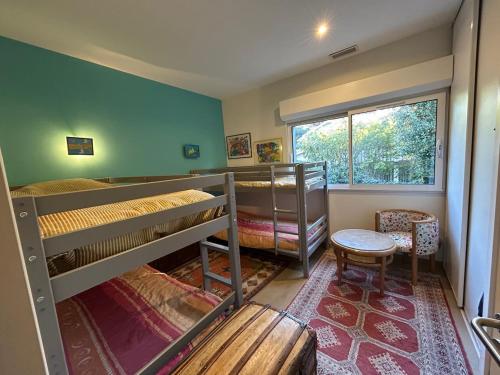 une chambre avec deux lits superposés et une fenêtre dans l'établissement Villa Pyla sur Mer, à La Teste-de-Buch