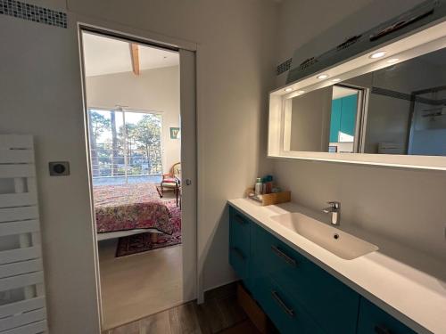 une salle de bain avec un lavabo et un miroir dans l'établissement Villa Pyla sur Mer, à La Teste-de-Buch