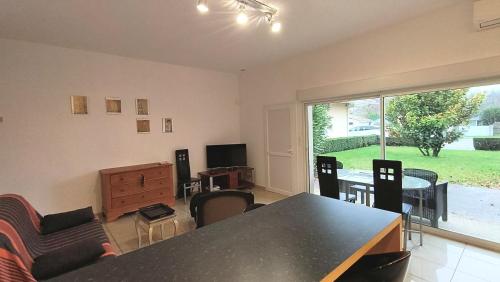 un salon avec une table, des chaises et une télévision dans l'établissement Gîte 