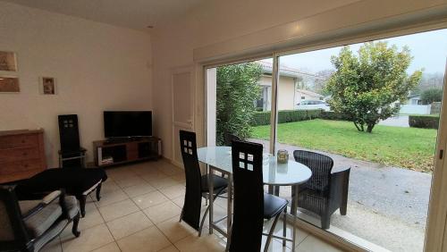un salon avec une table, des chaises et une télévision dans l'établissement Gîte 