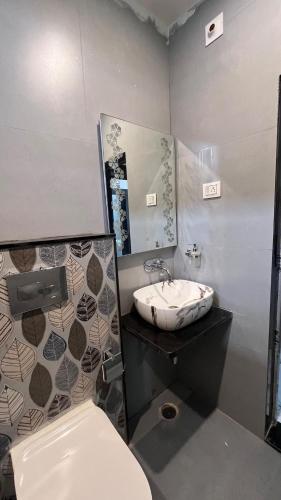 a bathroom with a sink and a toilet and a mirror at Luxe 2 BHK Apartment in Orchha