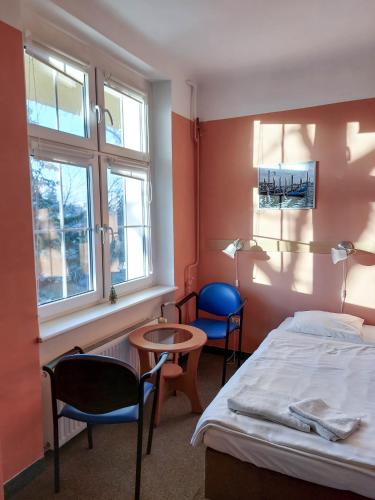 a bedroom with a bed and two chairs and a table at Pod starymi lipami in Szczecin